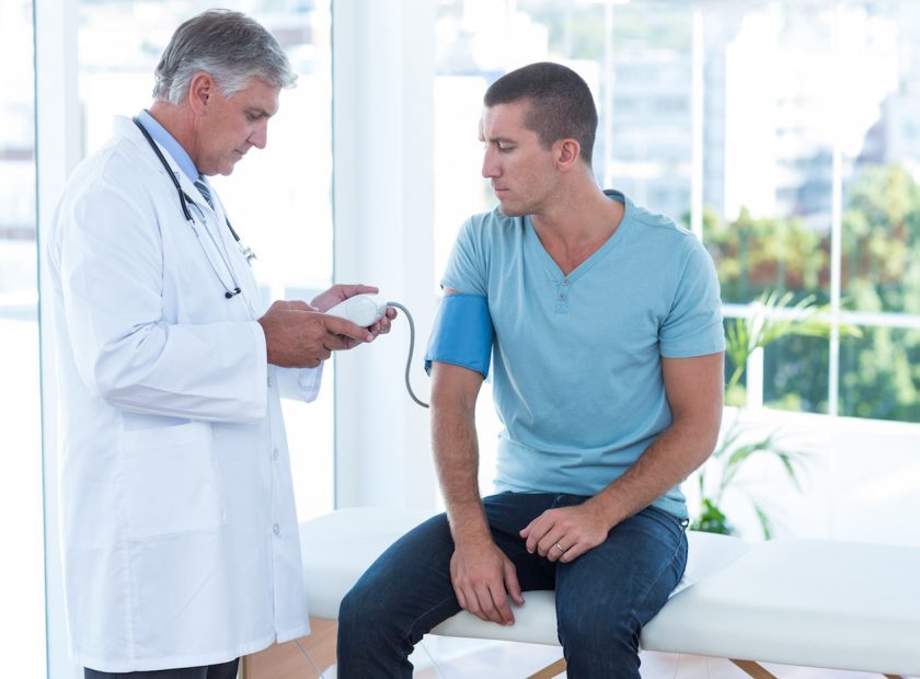 Doctor examining his patients blood pressure
